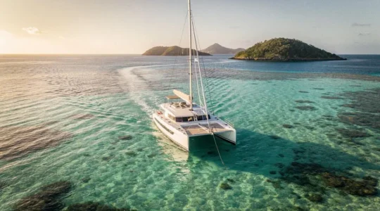 Catamaran de voyage ancré au-dessus d'un plateau corallien turquoise dans les Antilles, vue aérienne
